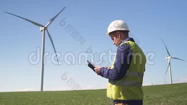 工程师站在风力机附近，检查开发信息